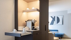 Un baño moderno con cafetera integrada, un perchero y un espejo.