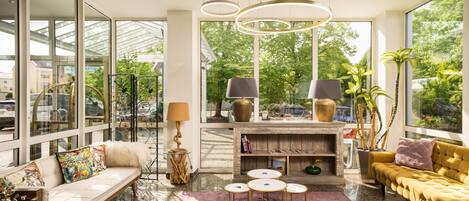 Una sala de estar moderna con un sofá, una mesa de centro, una chimenea y grandes ventanales que ofrecen vistas al exterior.