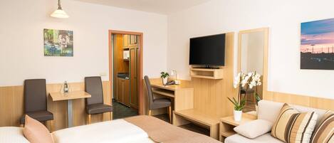 Une chambre d’hôtel comprenant un lit, un bureau, une télévision, un canapé et une salle de bain.