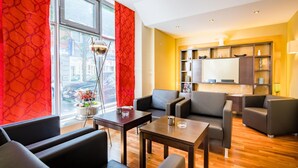 Una sala de estar moderna con sofás de cuero, una mesa de centro de madera y vistas de la ciudad a través de grandes ventanales.