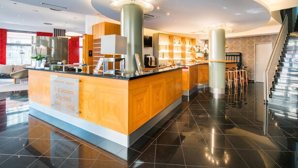 A modern hotel lobby with a reception desk, a staircase, and a bar area. - Best Western City-Hotel Braunschweig (Braunschweig)