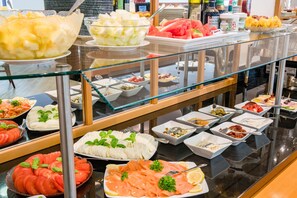 A buffet with various food options including salads, fruits, and seafood.