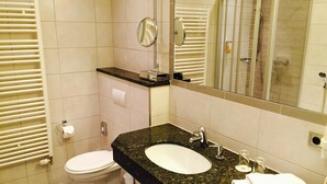 A modern bathroom with a toilet, sink, and mirror. - Best Western City-Hotel Braunschweig (Braunschweig)