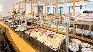 A buffet with various food items and a clock on the wall.
