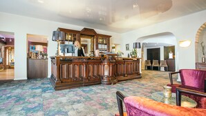 A lobby with a central bar area, seating, and a patterned carpet. - Hotel Westerkamp (Osnabrueck)