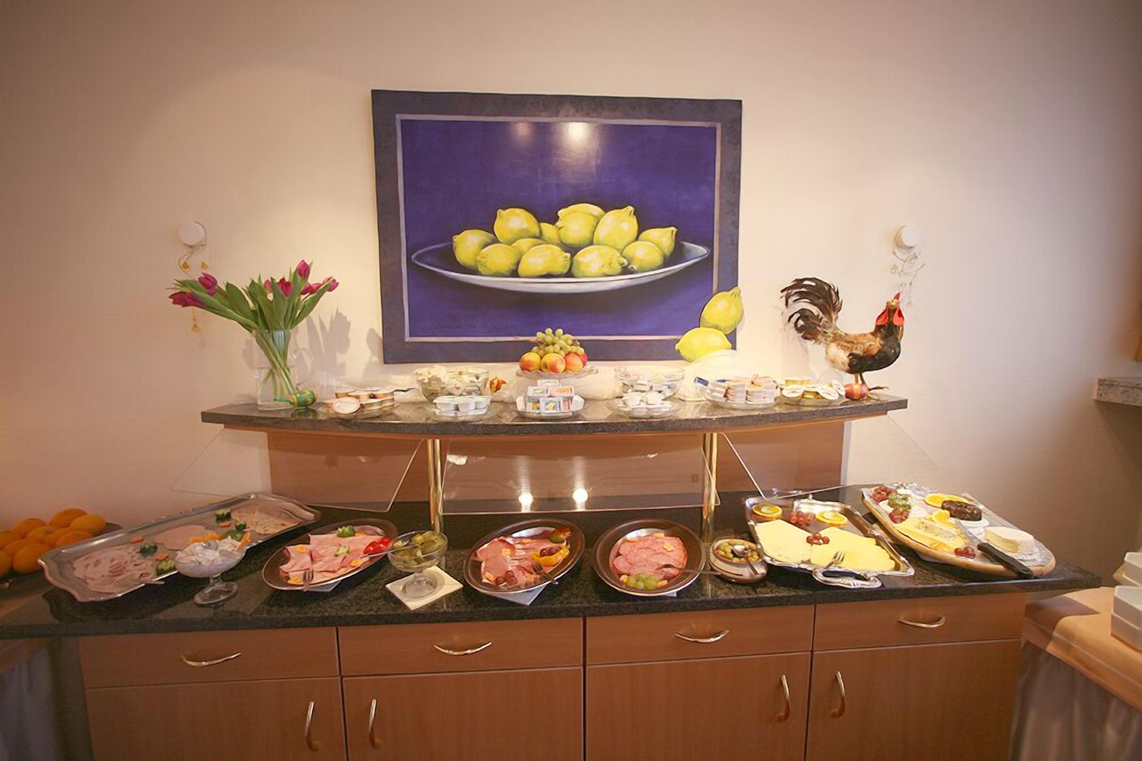 Montaje de bufé con diversas opciones de comida y un gallo decorativo.