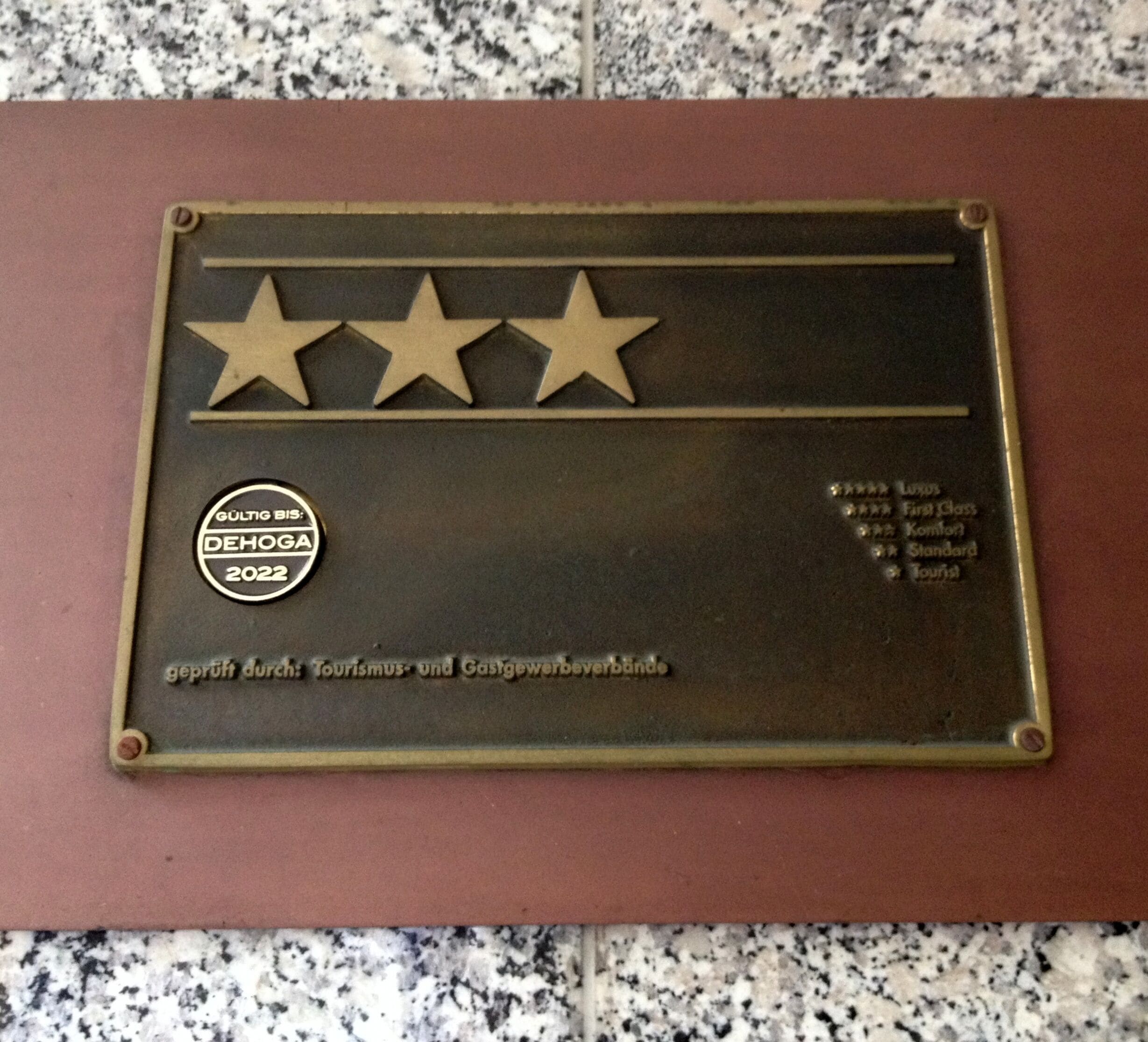 A plaque with three stars and text indicating a quality award.