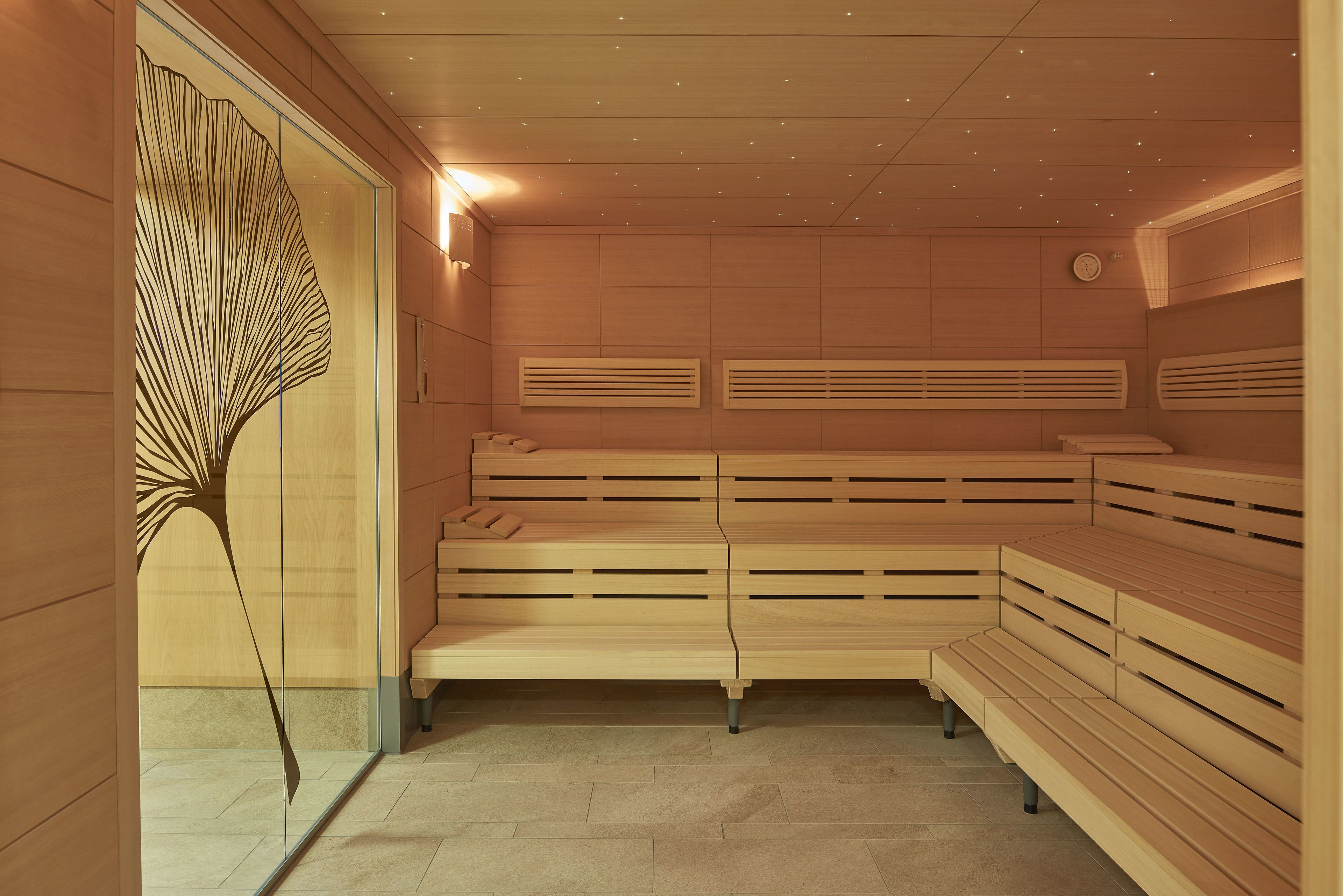 A sauna with wooden benches and a decorative wall piece.