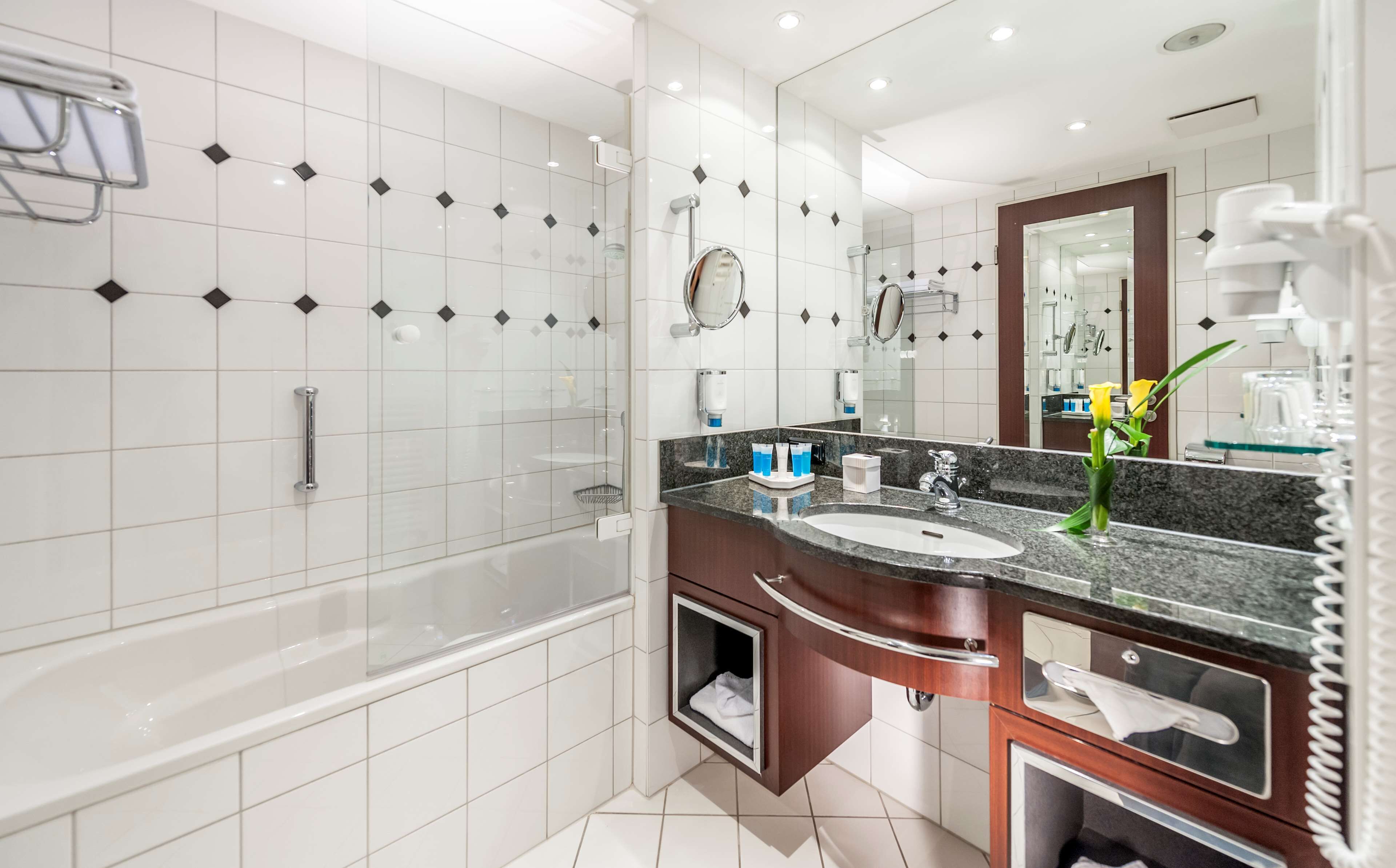 Ein modernes Badezimmer mit einer Badewanne, einem Waschtisch und einem großen Spiegel.