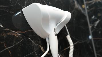 A hair dryer mounted on a black marble wall.