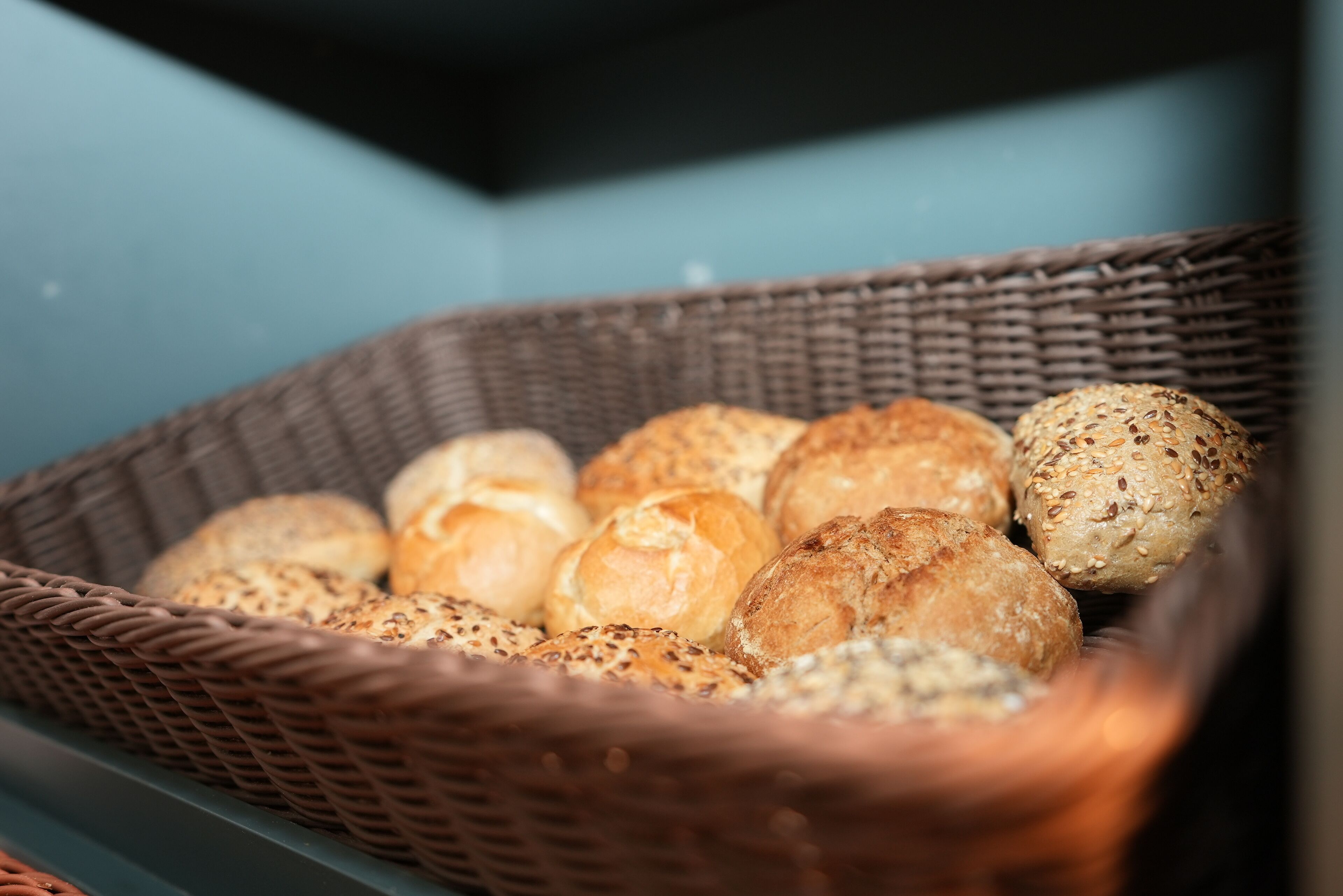 A wicker basket filled with various types of bread.