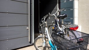 A bicycle parked outside a building with a metal door and a mailbox. - Hotel Gertrudenhof (Cologne)