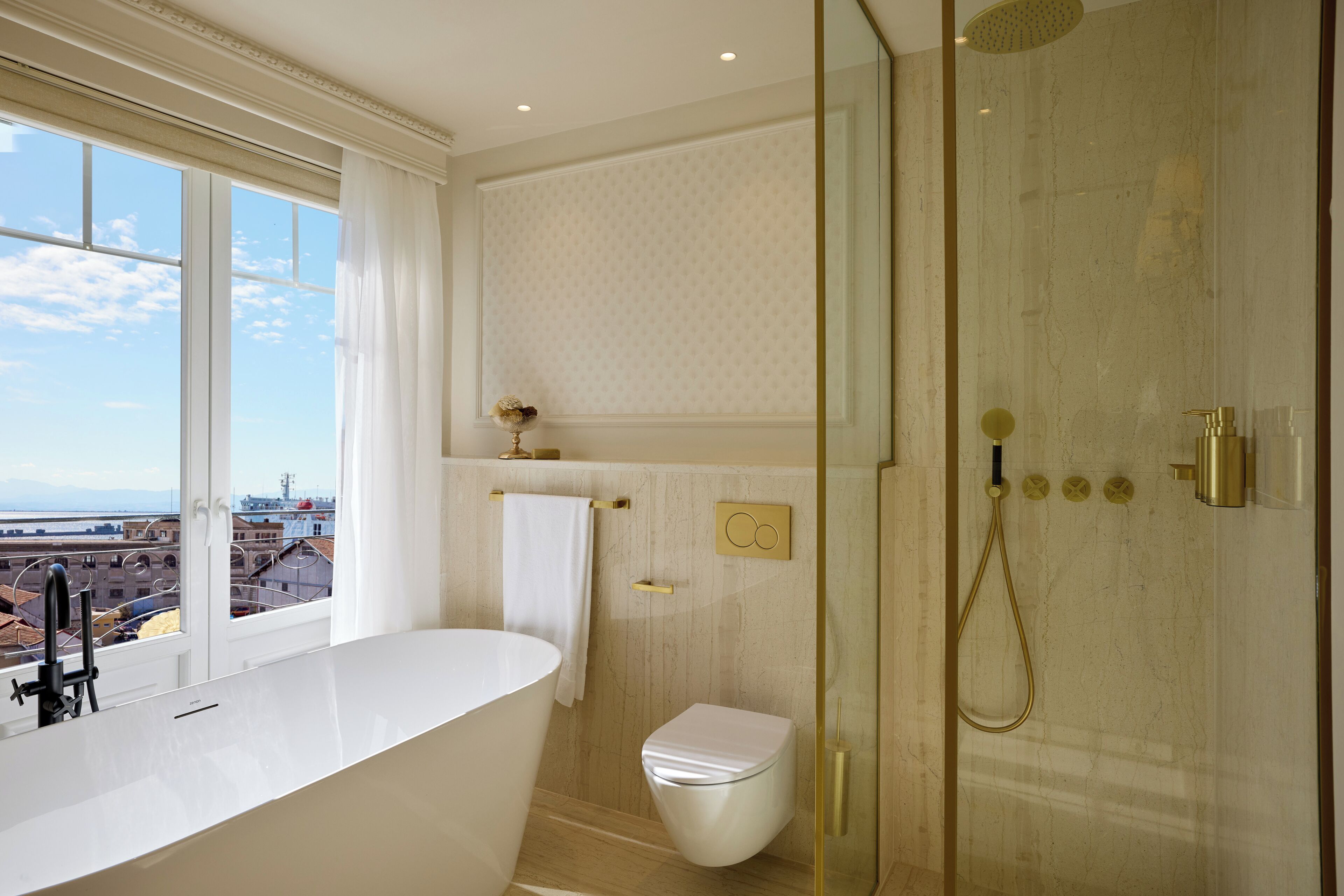 Un baño moderno con una bañera independiente, una ducha con cerramiento de vidrio y un inodoro.