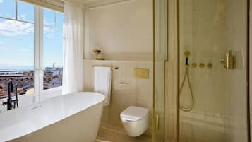 Un baño moderno con una bañera independiente, una ducha con cerramiento de vidrio y un inodoro.