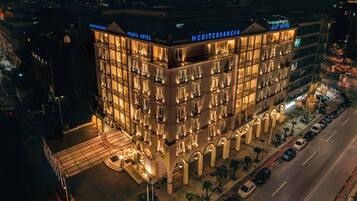 Un hôtel à plusieurs étages, doté d’une entrée imposante, d’un espace de stationnement et donnant sur la rue.