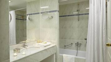 A modern bathroom with a marble sink, a bathtub, and a shower.