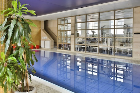 Una piscina techada, sillones reclinables de piscina