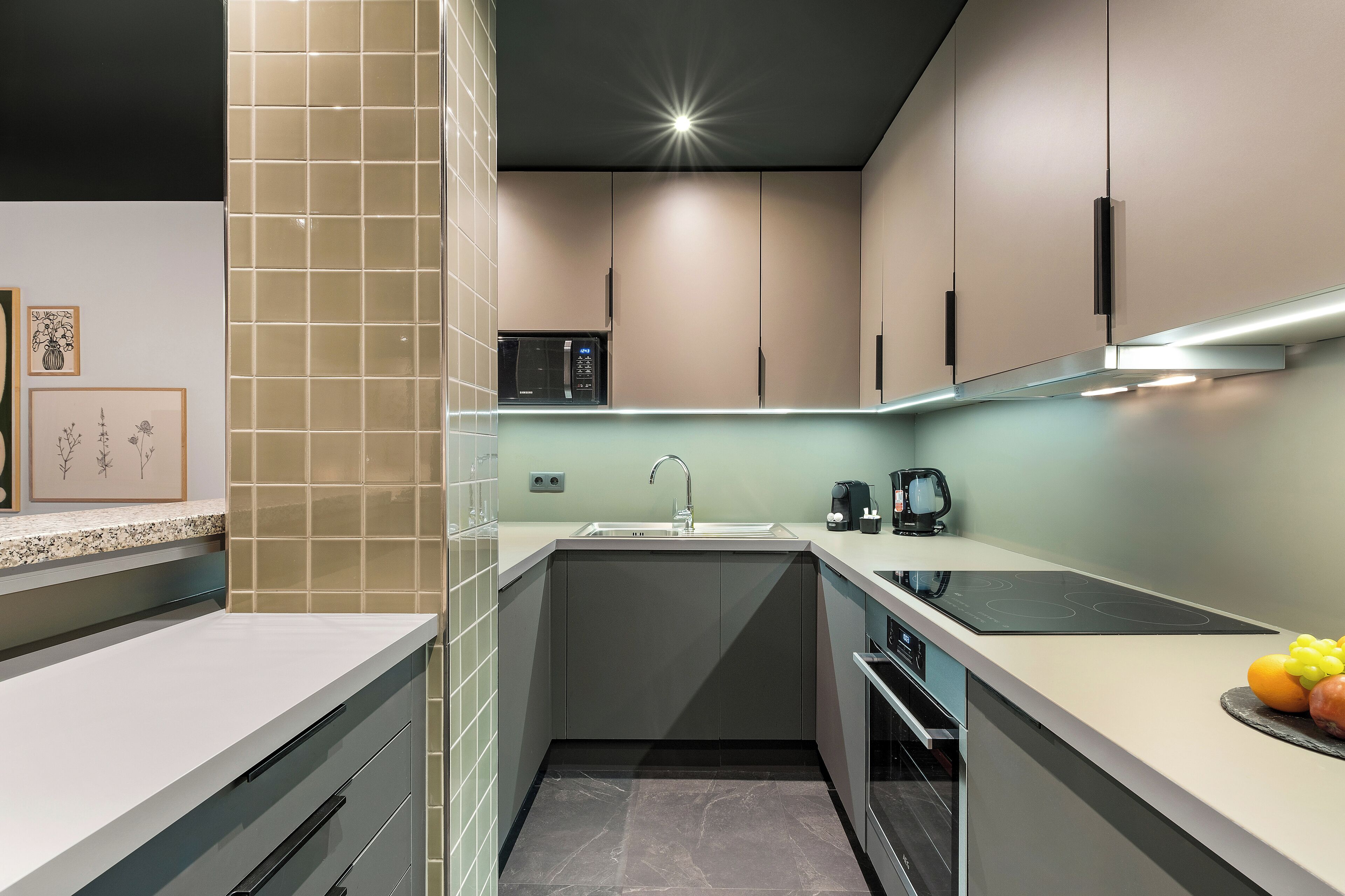 A modern kitchen with a built-in microwave, a sink, and a stove.