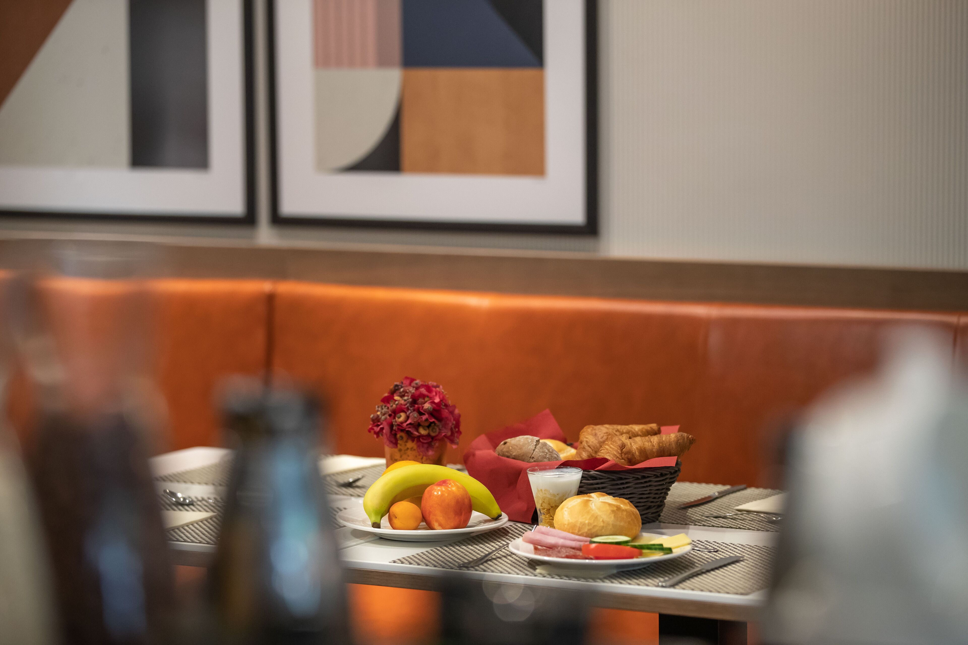 A dining table with breakfast items including fruits, bread, and a beverage.