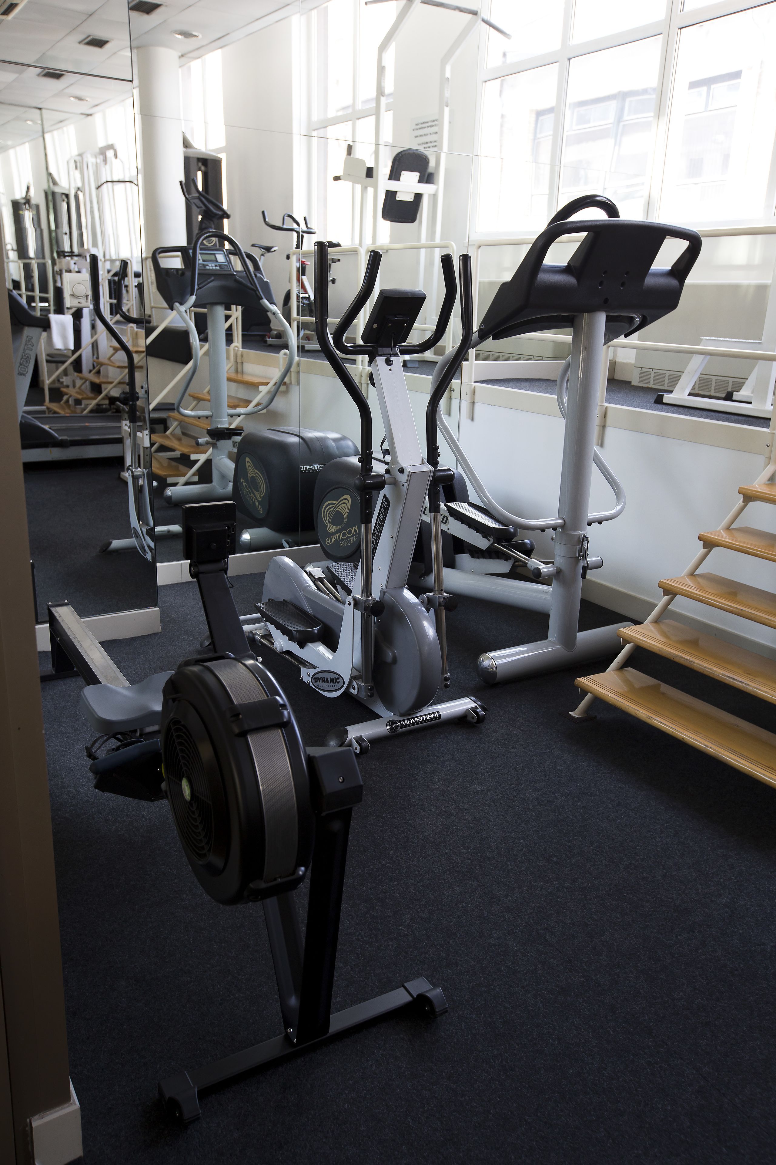 Une salle de sport équipée de divers appareils d’exercice, notamment des tapis de course et des appareils de musculation.