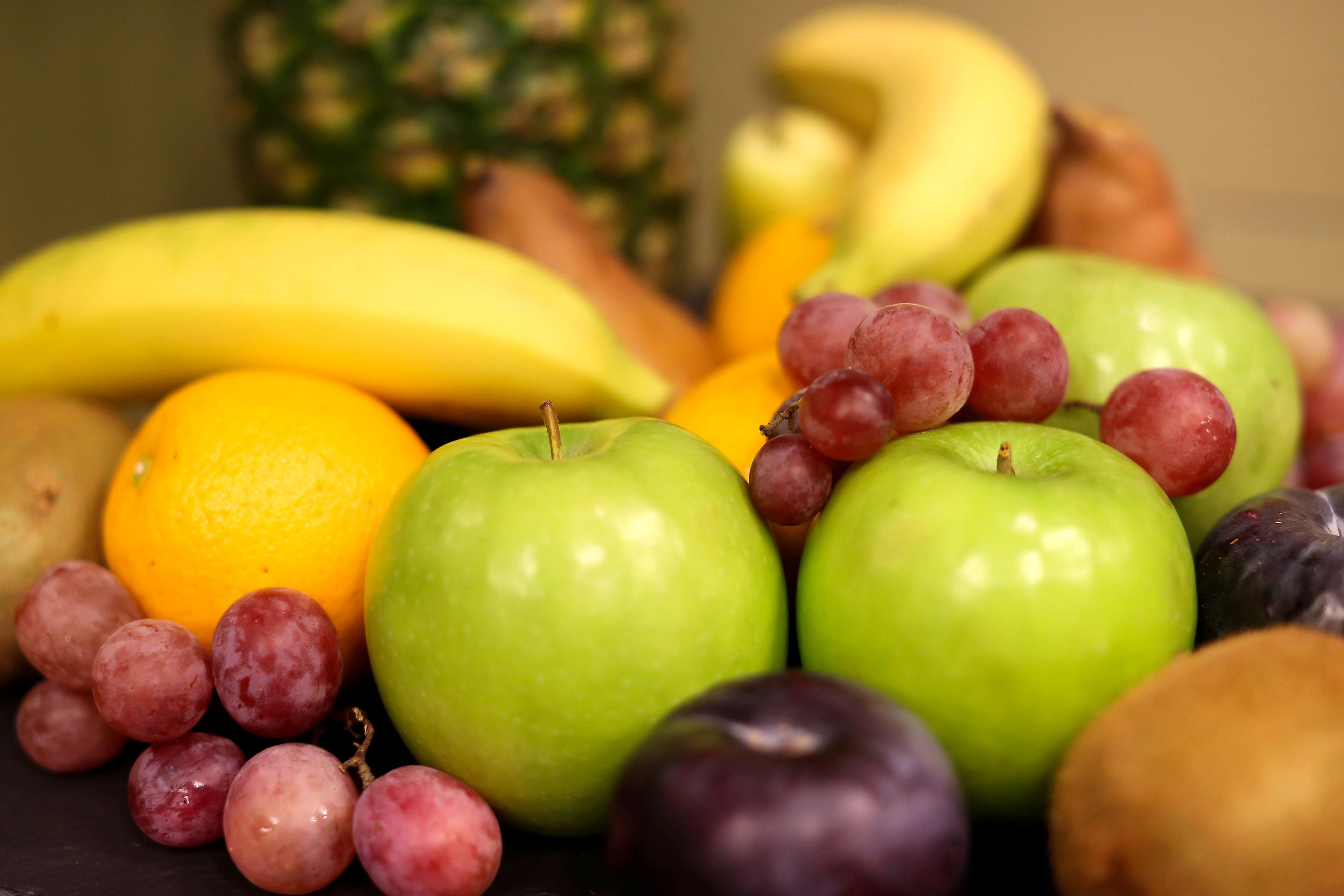 A variety of fruits including apples, grapes, bananas, and oranges.