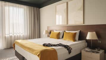 A hotel room with a bed, a nightstand, a lamp, and two wall art pieces.