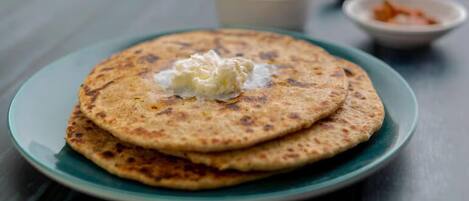 A plate with three pancakes and a dollop of butter on top.