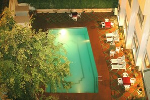 Una piscina cubierta, una piscina al aire libre, tumbonas