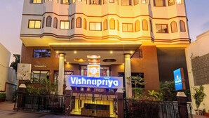 A hotel with a modern facade, a prominent entrance, and a sign indicating it is the Vishnupriya Hotel. - ECKO Premier Vishnupriya (Udaipur)