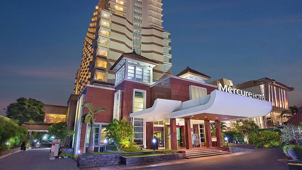 Un hotel de gran altura con una entrada destacada y un cartel grande que dice "Mercure Hotel".