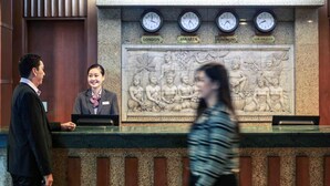 Un mostrador de recepción con relojes que muestran la hora de Londres, Yakarta, Hong Kong y Los Ángeles.
