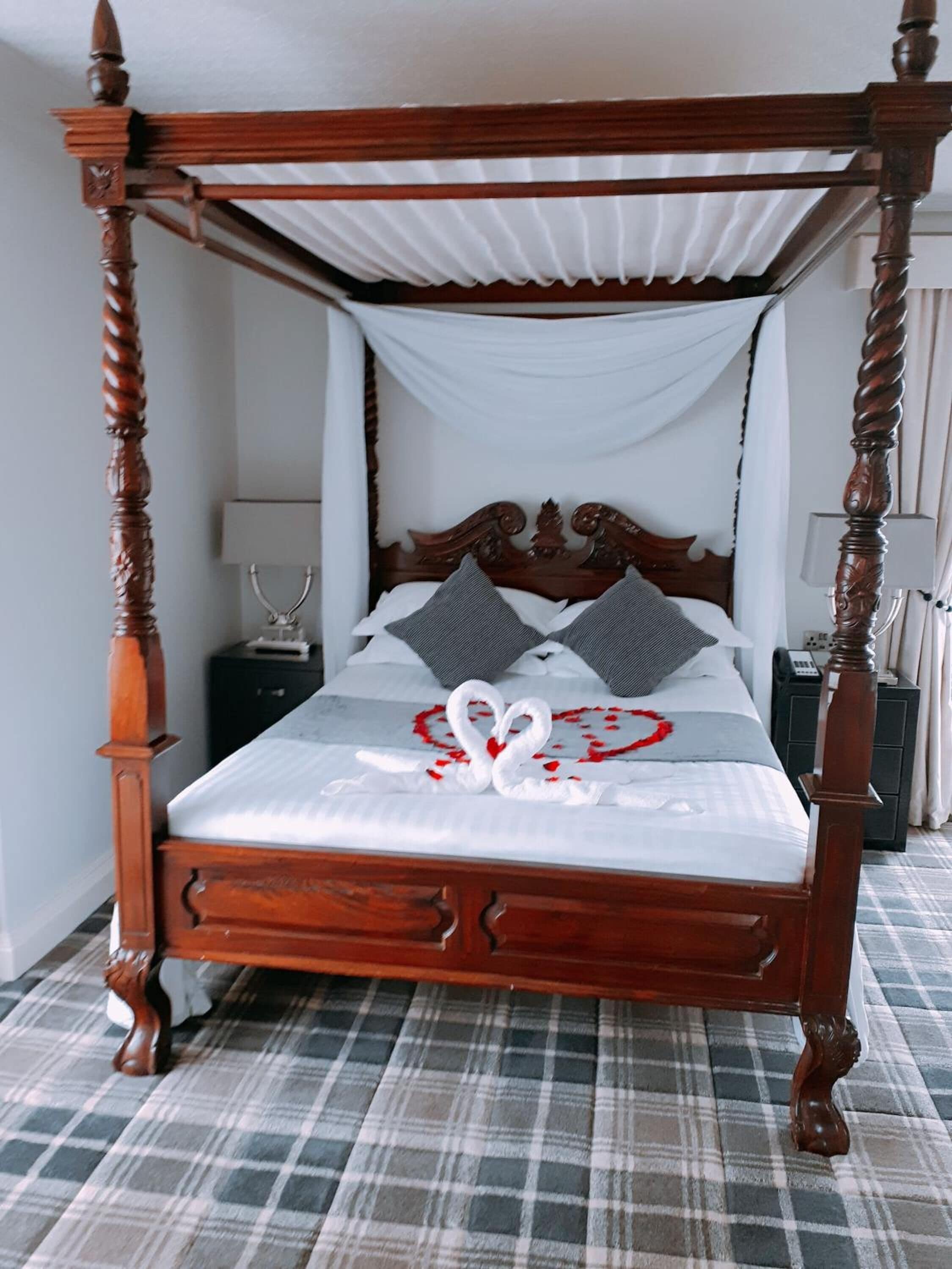Una cama con dosel, un suelo escocés y una decoración con forma de corazón en la cama.