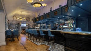 A bar area with multiple seating options, a bar counter, and a variety of bottles and glasses on display. - Treacys Oakwood Hotel (Shannon)