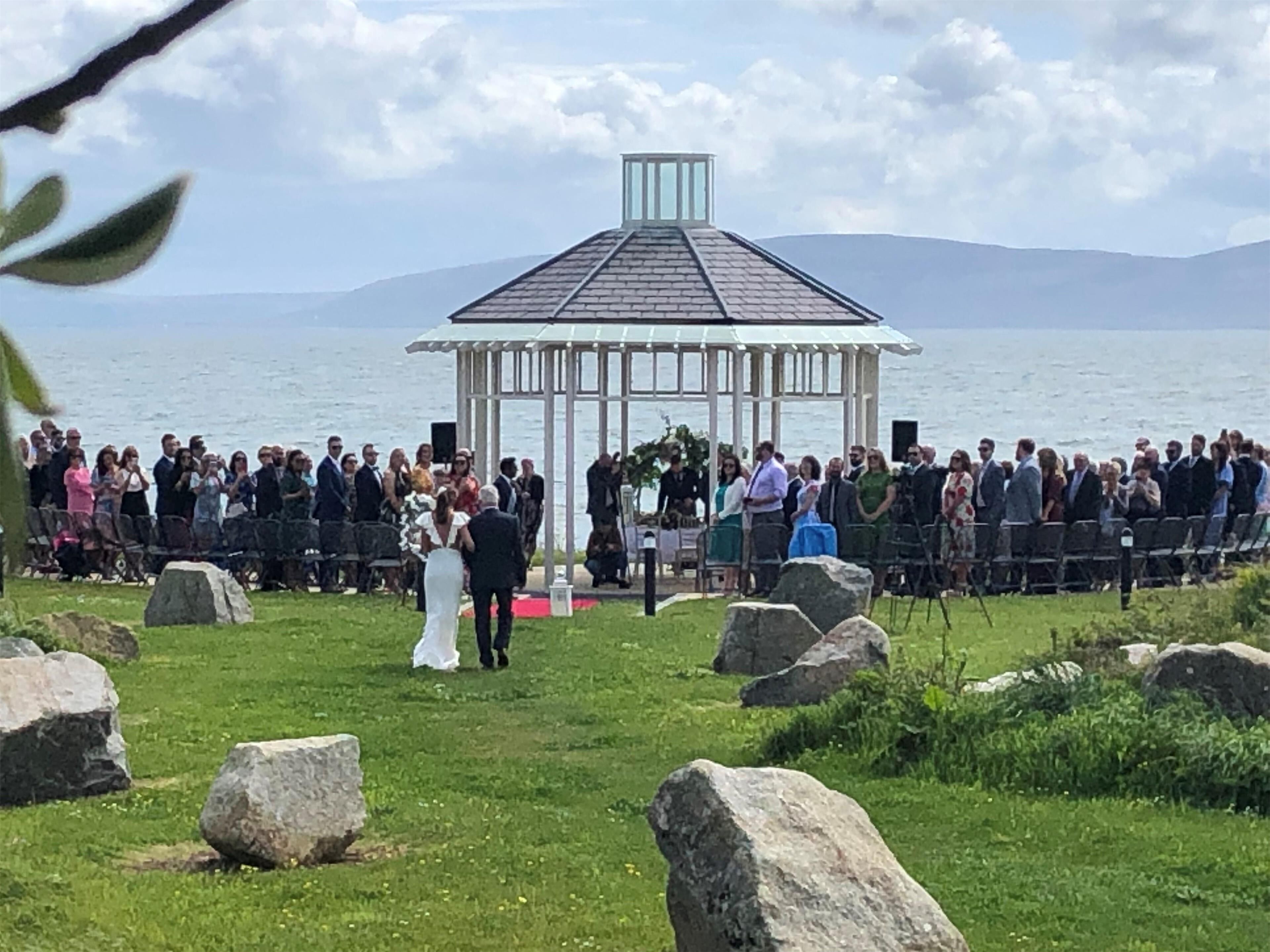 A gazebo with a clear view of the sea and mountains in the background.