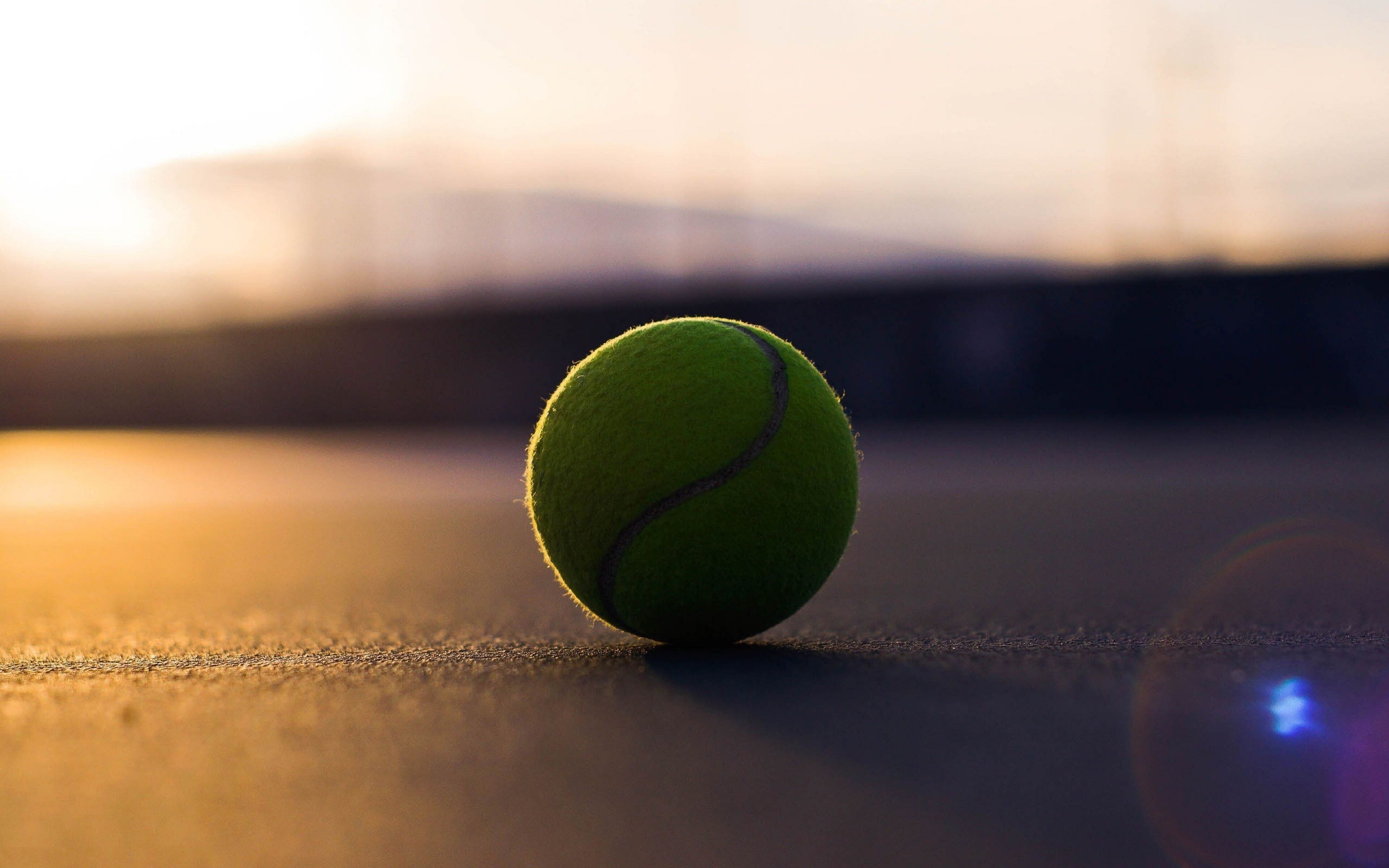 A tennis ball on a smooth surface with a blurred background.