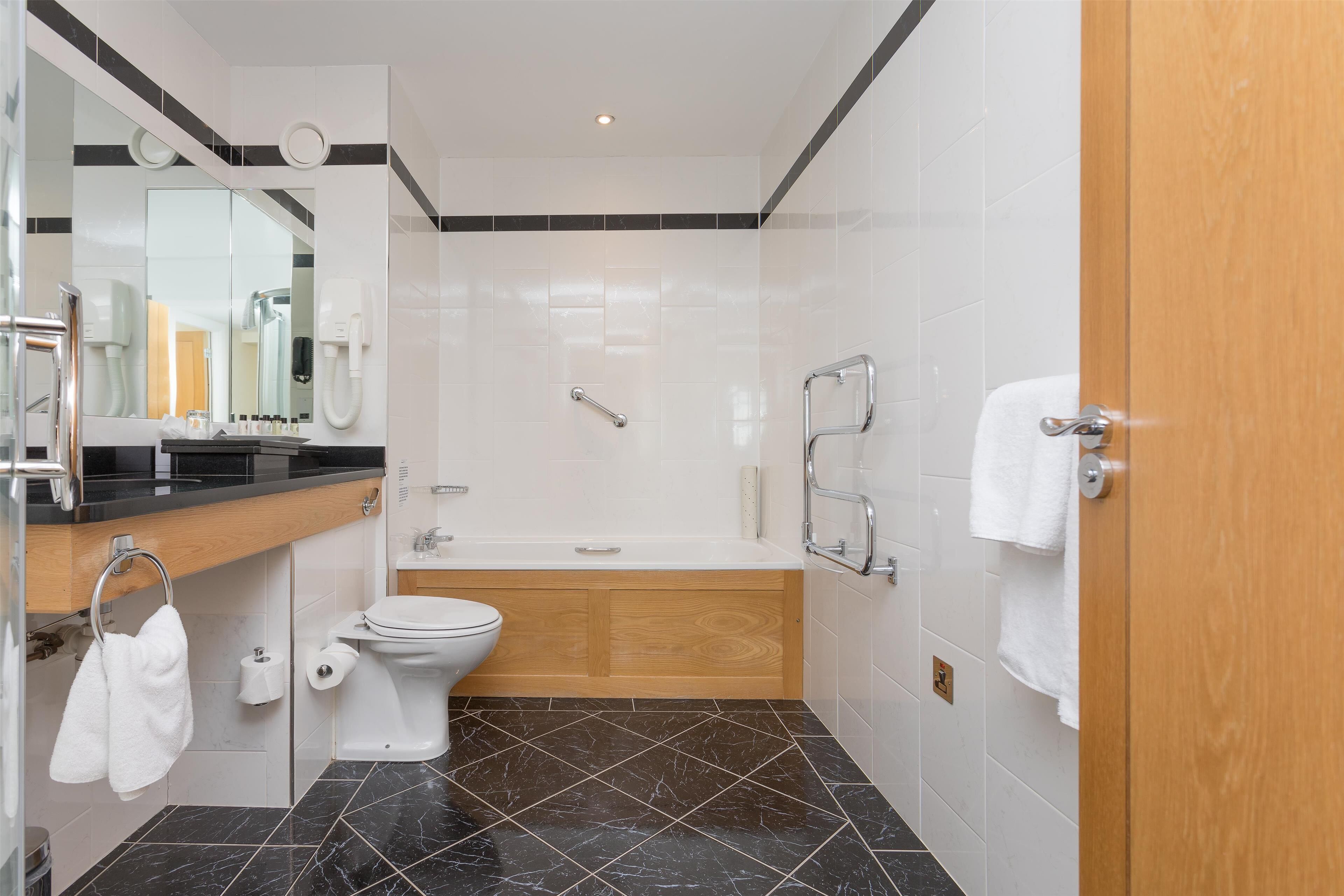 Un bagno moderno con toilette, lavandino e vasca da bagno.