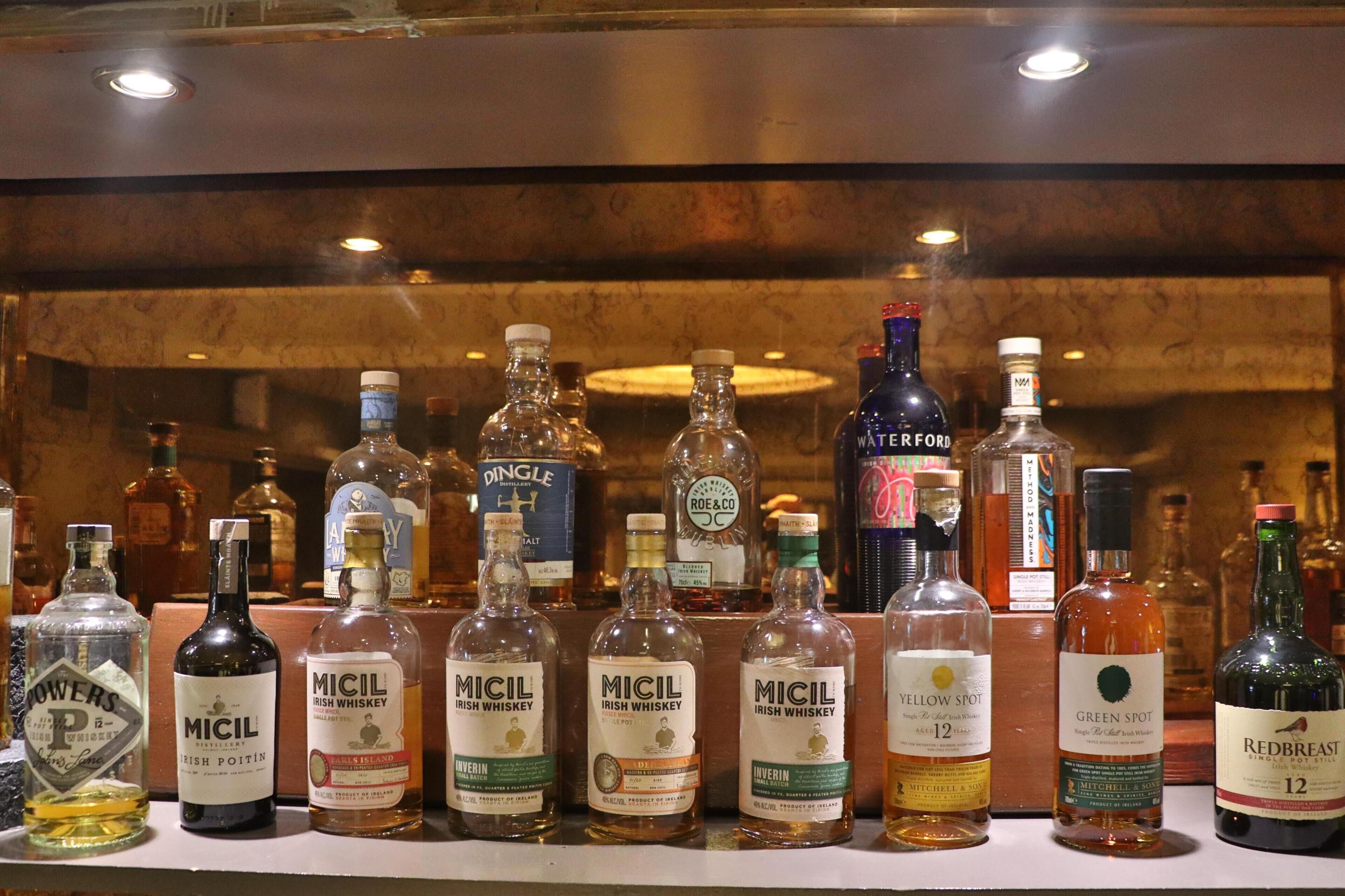 A variety of liquor bottles displayed on a shelf.