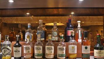 A variety of liquor bottles displayed on a shelf.