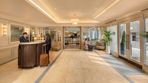 A hotel lobby with a reception desk, seating area, and large windows. - Brooks Hotel (Dublin)