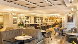 A spacious hotel lobby with a bar area, seating arrangements, and a modern ceiling design. - Brooks Hotel (Dublin)