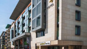 Un hotel moderno con un letrero llamativo, ventanas amplias y una fachada limpia.