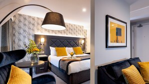 A modern hotel room with a bed, a bedside table, a lamp, and a large window. - Camden Court Hotel (Dublin)