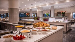 A buffet area with various food items and a coffee station.