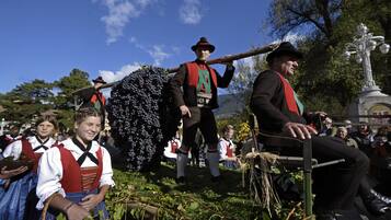 Un grupo de personas con vestimenta tradicional, posiblemente en un evento cultural o festival, con un fondo de árboles y cielo despejado.
