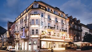 Un hôtel à plusieurs étages, reconnaissable à son grand panneau « EUROPA », doté d’une terrasse et d’une façade bien éclairée.