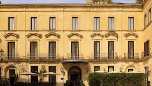A historic building with a symmetrical facade, multiple windows, and a central entrance. - Patria Palace Hotel Lecce - Leading Hotels of the World (Lecce)