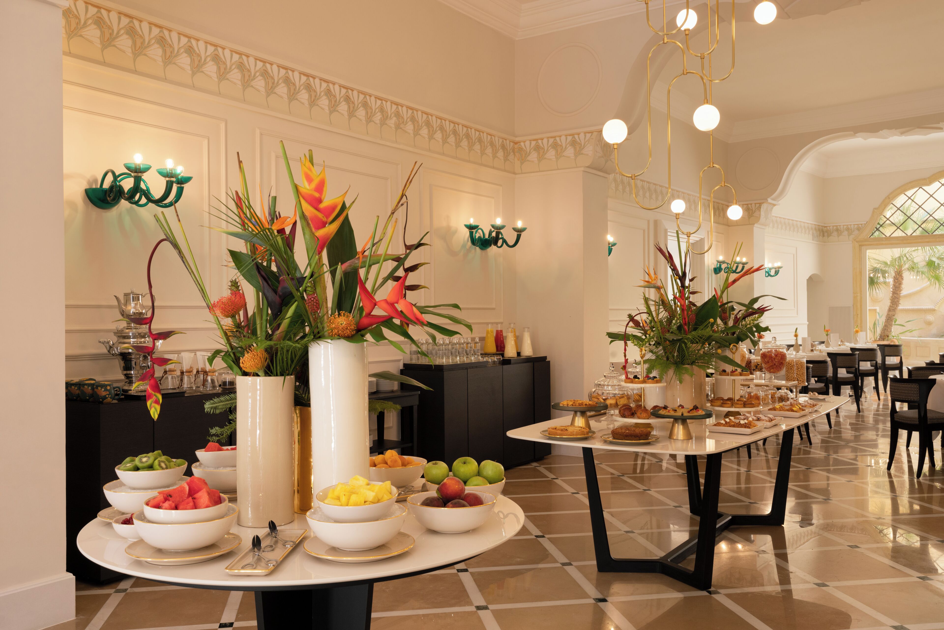 Montaje de bufé con diversas opciones de comida y plantas decorativas.
