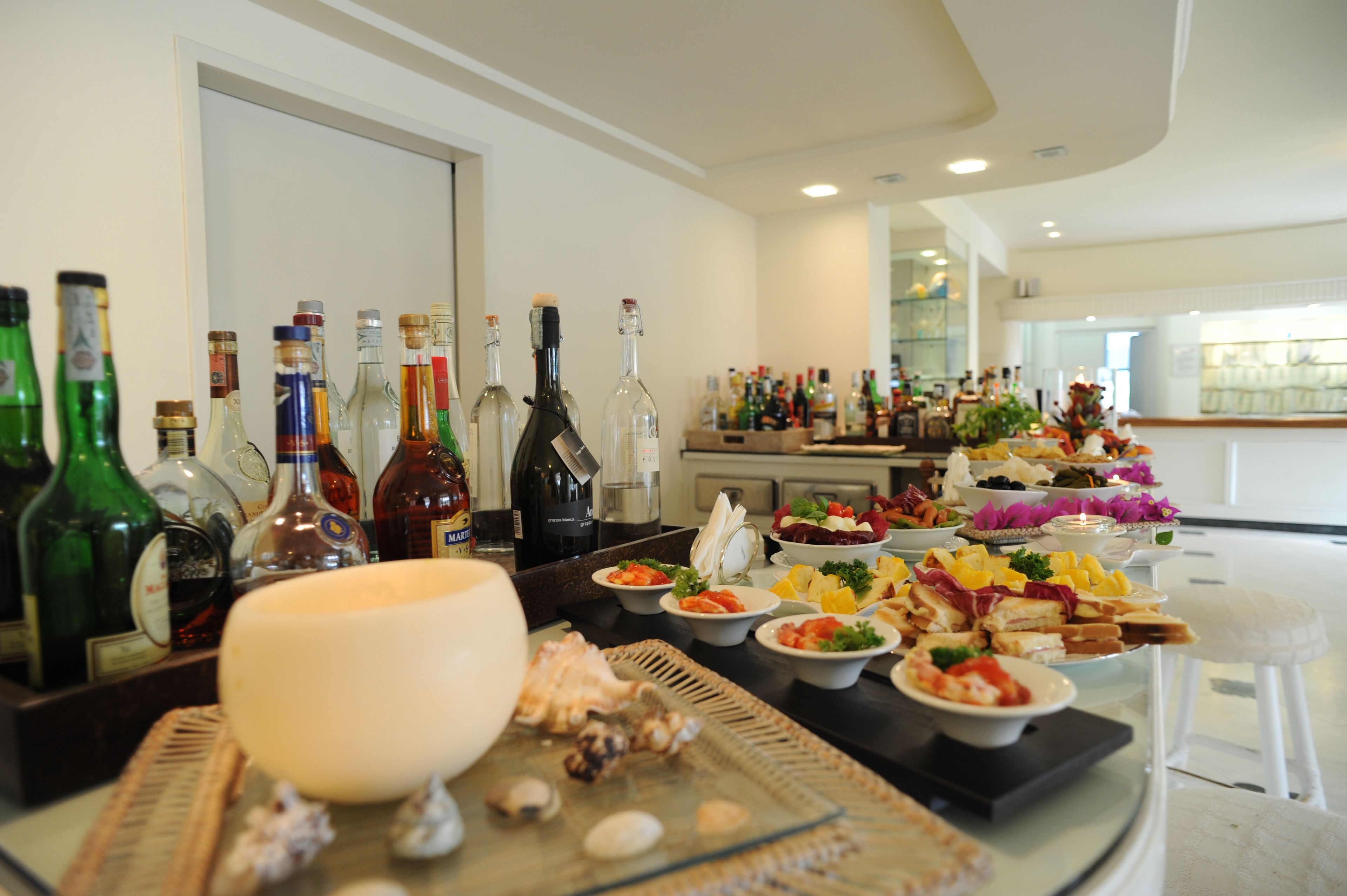 A buffet setup with various food items and a selection of liquor bottles.