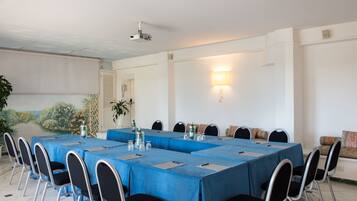 A conference room with a long table, chairs, and a projector.