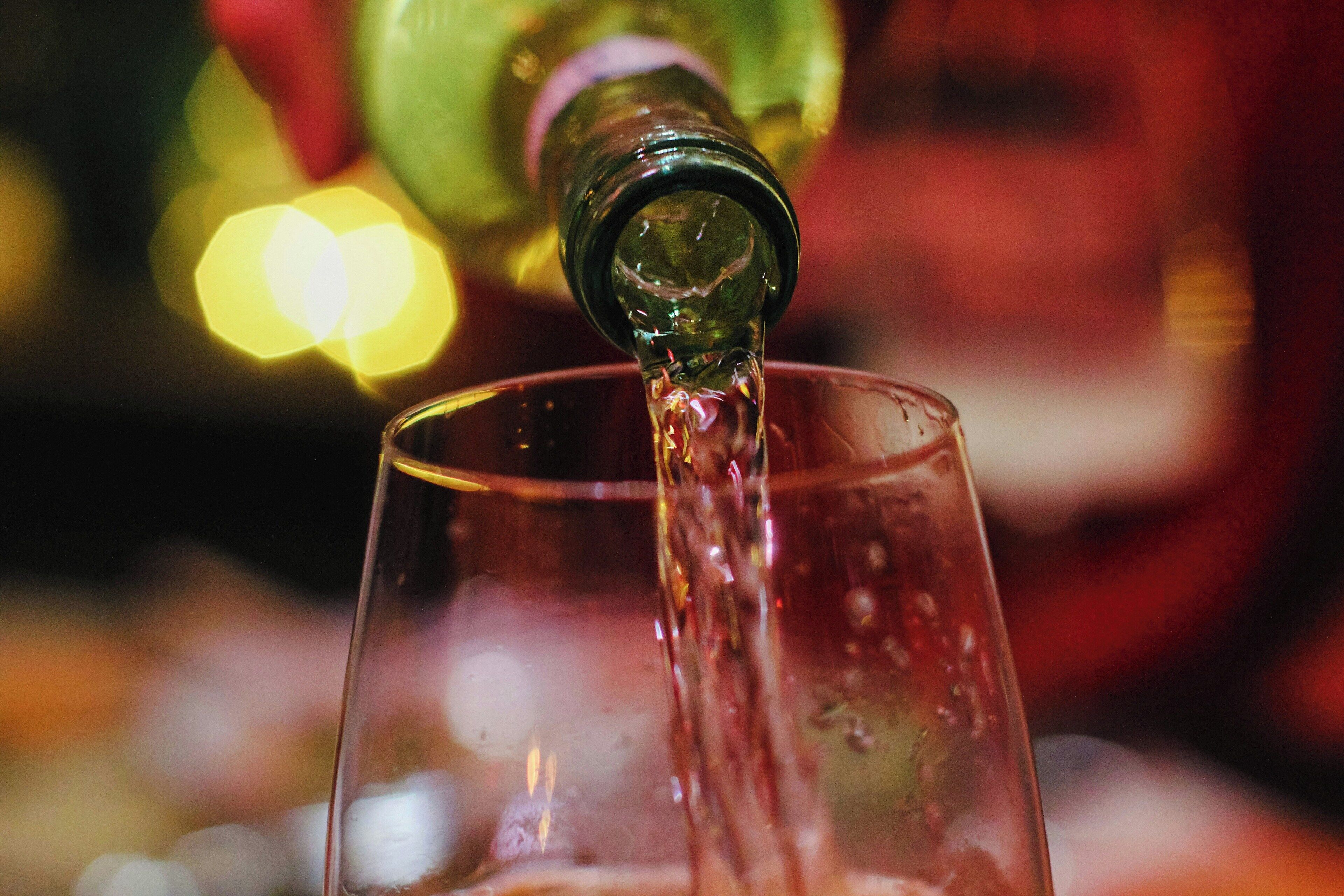 A glass being filled with a liquid, likely a beverage.